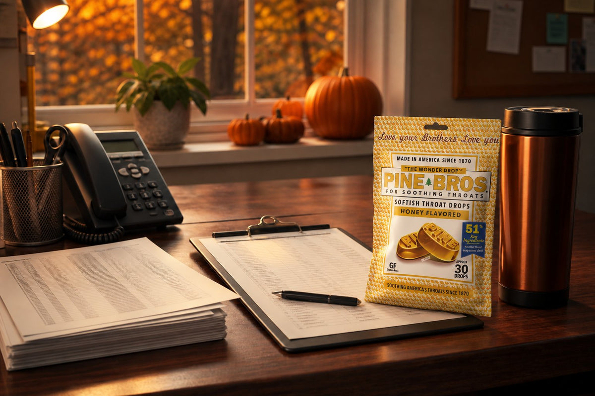 A volunteer desk in October with a clipboard, a stack of address sheets, a phone, and a Pine Brothers Honey pouch beside a thermos, warm evening light, no people, no added text