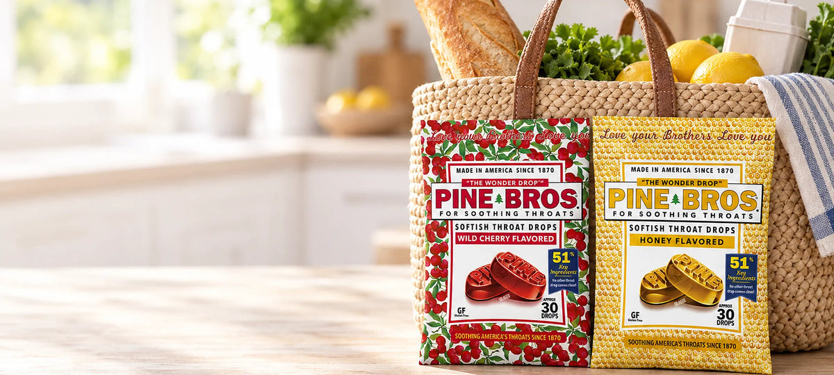 Pine Brothers Wild Cherry and Honey softish throat drop bags leaning on a woven market basket in a sunny kitchen
