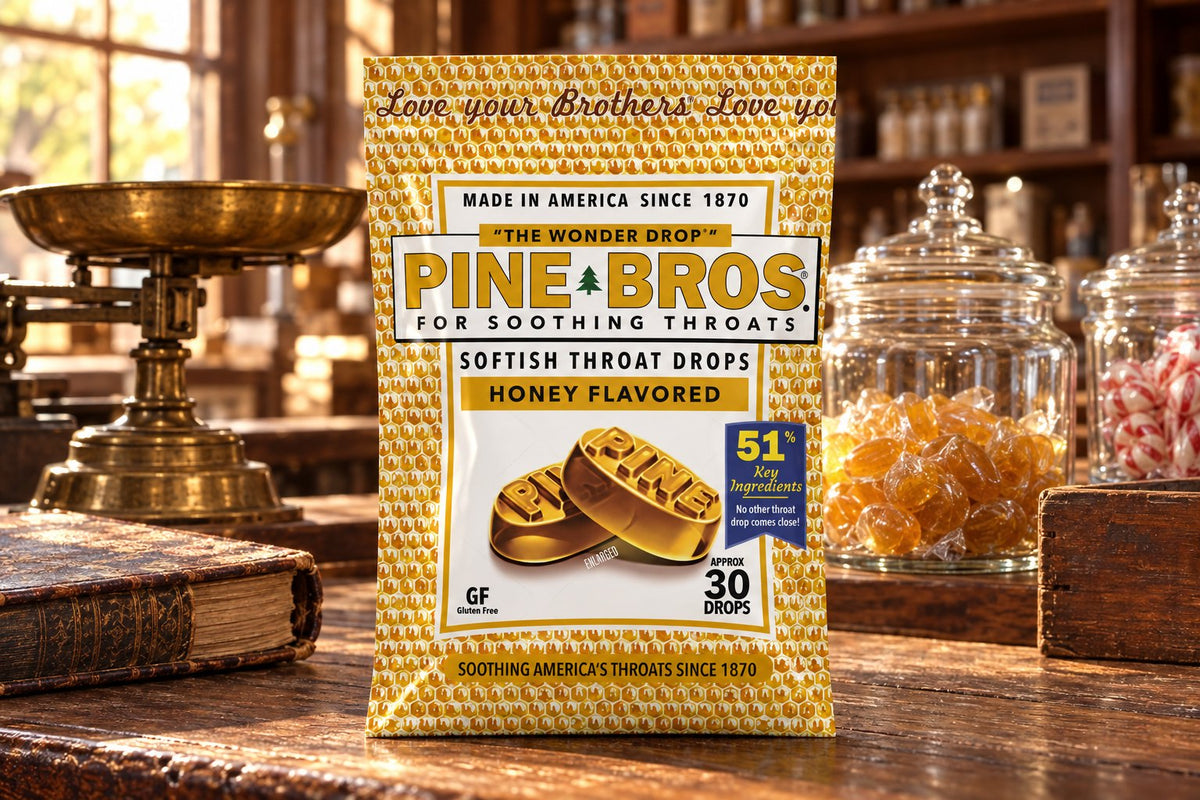 A Pine Brothers Honey pouch on an old general-store counter with a brass scale, a ledger and glass jars of amber drops